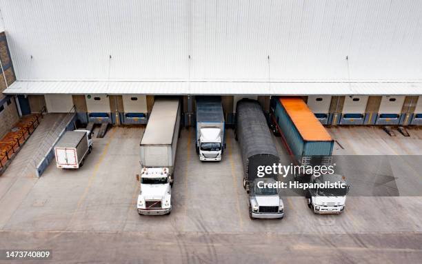 trucks parked in a distribution warehouse ready to deliver some cargo - loading bay stock pictures, royalty-free photos & images