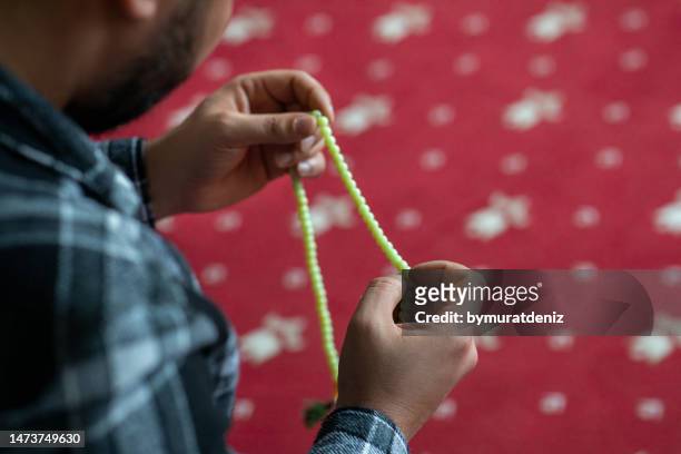 man holding prayer beads in mosque - sufismo imagens e fotografias de stock