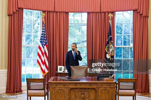 In this handout provided by the White House, U.S. President Barack Obama talks on the phone with Solicitor General Donald Verrilli in the Oval...