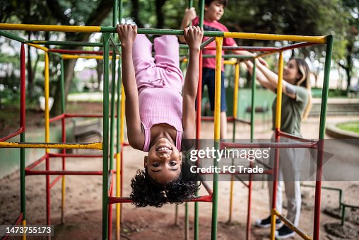 Portrait of a girl upside down in a jungle gym in a park Portrait of a girl upside down in a jungle gym in a park