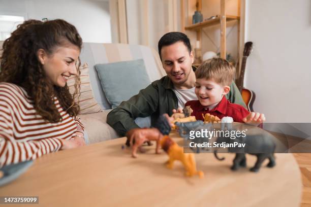 caucasian father, mother and son playing with toy animals at home. - toy animal stockfoto's en -beelden