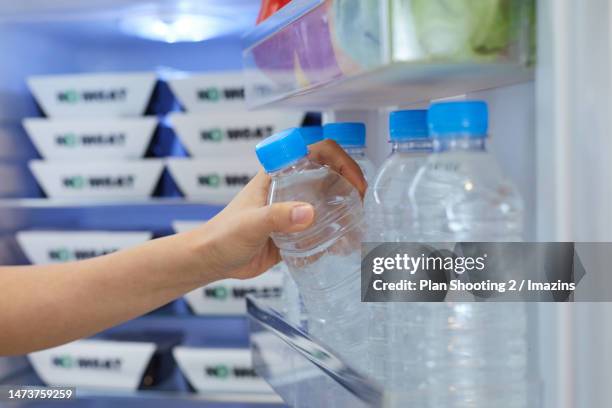 woman, refrigerator, plastic, drinking water, plastic bottle, water - water bottles in fridge stock pictures, royalty-free photos & images