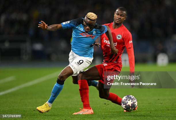 Victor Osimhen of SSC Napoli is challenged by Evan Ndicka of Eintracht Frankfurt during the UEFA Champions League round of 16 leg two match between...