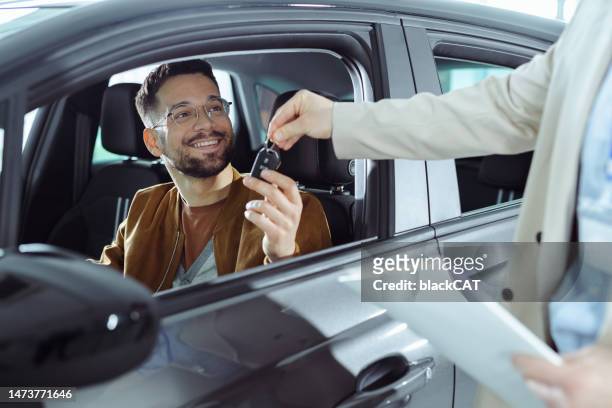 a young man buys a new car - people in car stockfoto's en -beelden