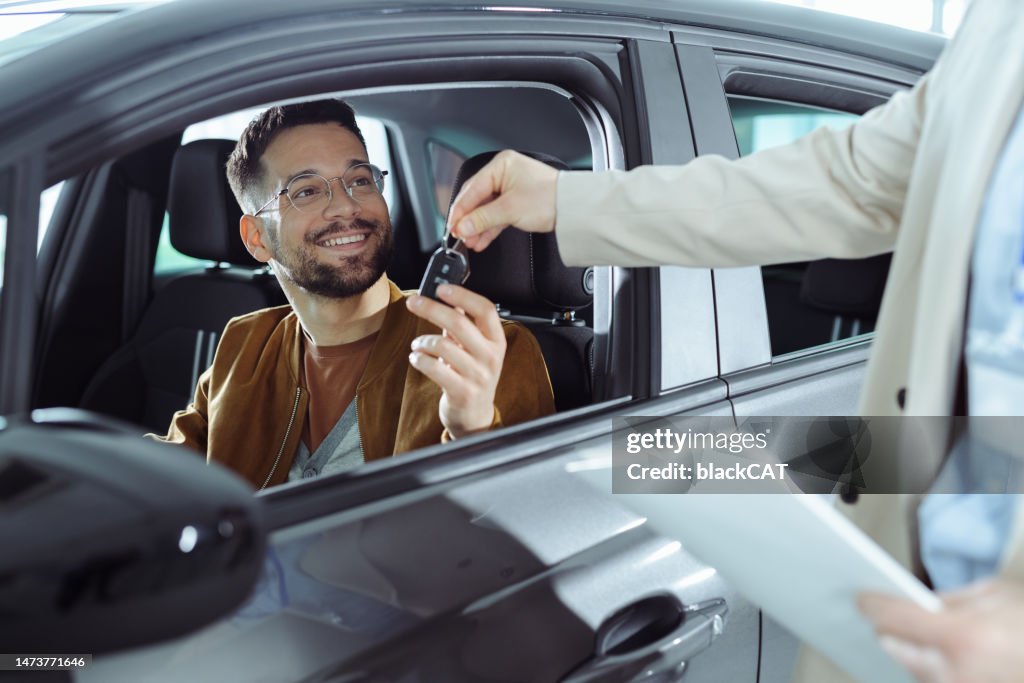 A young man buys a new car