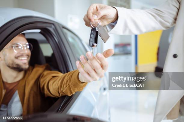 a young man buys a new car - buying a car 個照片及圖片檔