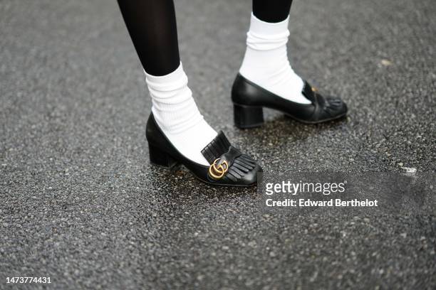 Emy Venturini wears black tights from Calzedonia, white socks from Uniqlo, Gucci black leather loafers shoes, during a street style fashion photo...
