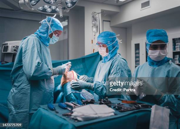 chirurghi e infermieri che eseguono un intervento chirurgico al ginocchio sul paziente in sala operatoria - knee replacement surgery foto e immagini stock