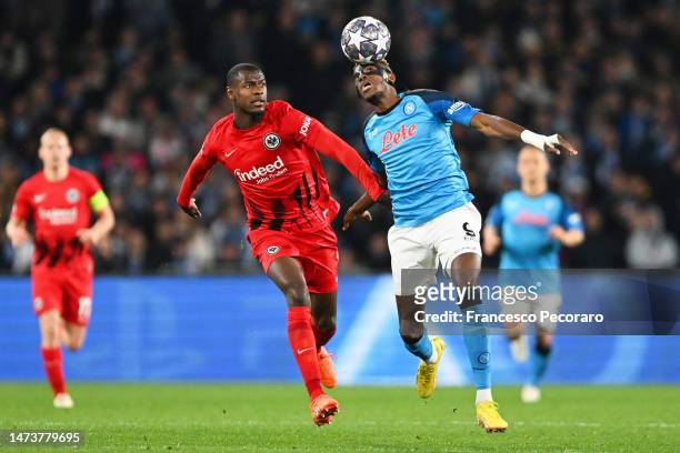 Victor Osimhen of SSC Napoli is challenged by Evan Ndicka of Eintracht Frankfurt during the UEFA Champions League round of 16 leg two match between...