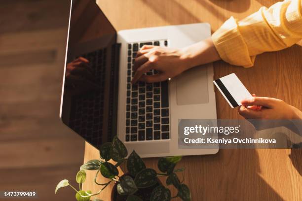 online payment,man's hands holding a credit card and using smart phone for online shopping - phone credit card photos et images de collection