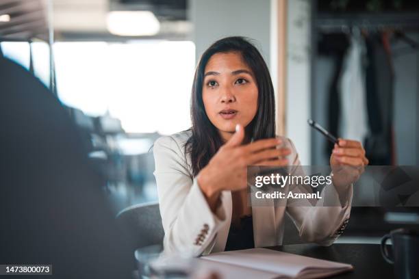 japanese businesswoman talking and using hands - showing pen stock pictures, royalty-free photos & images