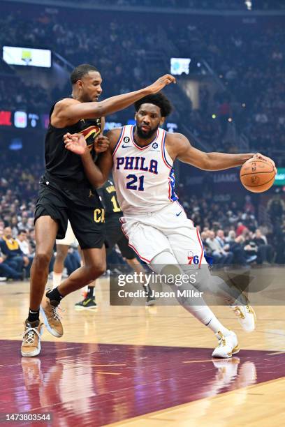 Joel Embiid of the Philadelphia 76ers drives to the basket around Evan Mobley of the Cleveland Cavaliers during the first half of the game at Rocket...