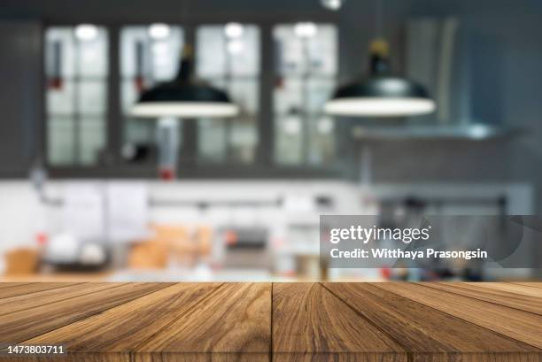 wooden tabletop over defocused kitchen background - focus on foreground food stock pictures, royalty-free photos & images