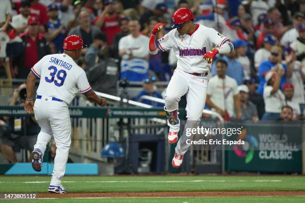 Juan Soto of The Dominican Republic celebrates with third base coach Ramon Santiago after hitting a home run in the third inning of the World...