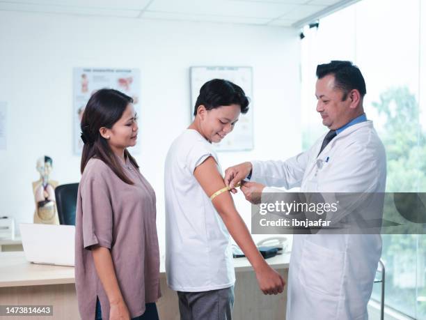 doctor measure the arm of patient - fat asian boy stock pictures, royalty-free photos & images
