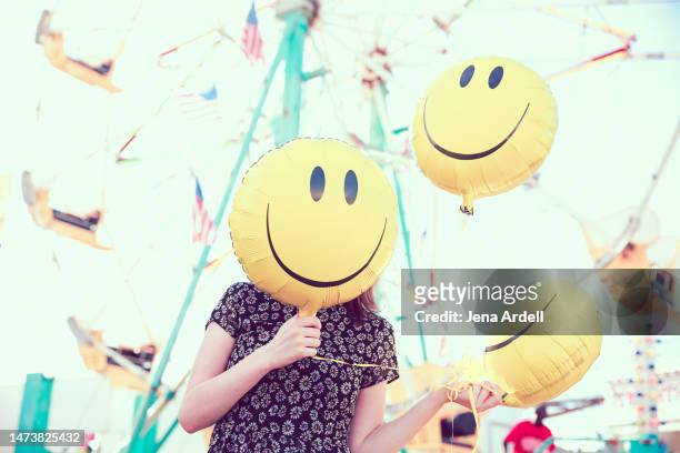 happiness and positivity, positive attitude, summer fun happy smiley face mask hiding face - woman smiley face stock pictures, royalty-free photos & images