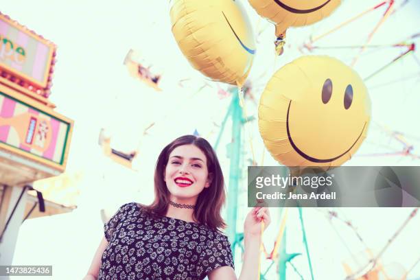 positive attitude woman smiling outdoors, happy woman having fun, happiness concept smiley face balloons - smiley face balloon stock pictures, royalty-free photos & images