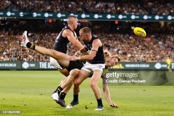 Tom J. Lynch of the Tigers collides with Sam Docherty of the Blues and Jacob Weitering of the Blues during the round one AFL match between Richmond...