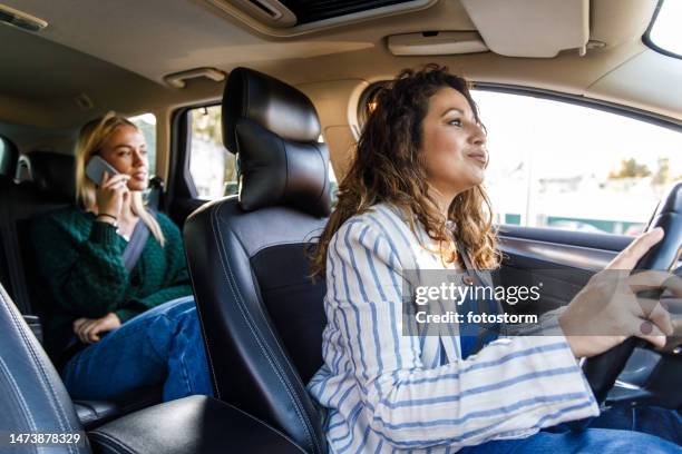 taxifahrerin, die den kunden zu ihrem standort bringt - fahrgemeinschaft stock-fotos und bilder