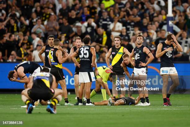 Players from both sides react on the final siren during the round one AFL match between Richmond Tigers and Carlton Blues at Melbourne Cricket...