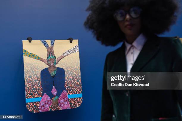 Artist Elsa James in front of a piece of art by artist Patrick Quarm entitled 'Make you no see, Make you no hear, Make you no speak' during a press...