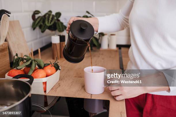 woman pouring coffee in cup at home - coffee plunger stock-fotos und bilder