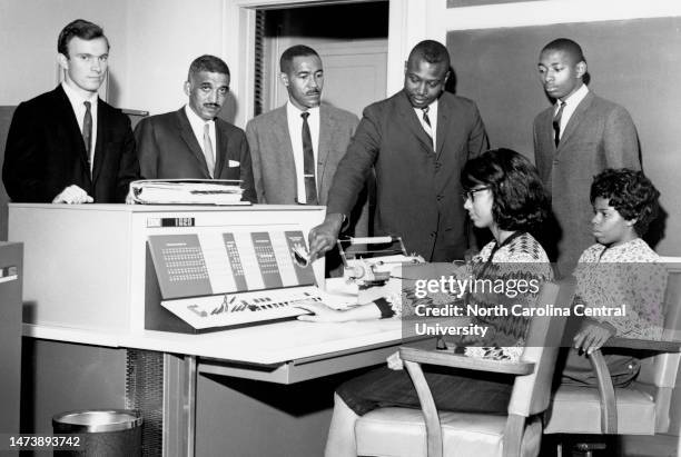 Dr. Samuel P. Massie, Mr. John D. Harrell and faculty members observe university students operating data processing equipment.