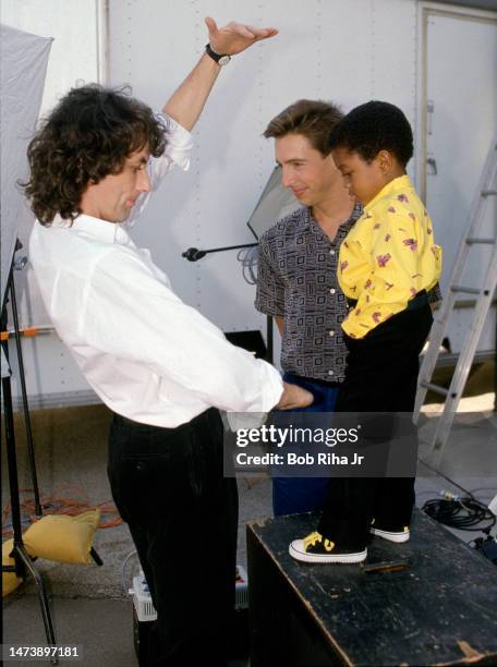 Photographer Jim Shea works to take a promotion photo with Ron Reagan Jr. And Emmanuel Lewis while filming a segment on location of television show...