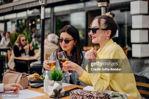 two ladies having wine in outdoor restaurant - victory dinner stockfoto's en -beelden