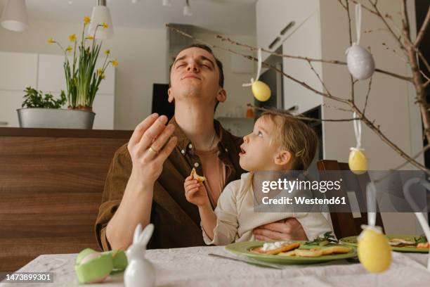 father and daughter enjoying pancakes for breakfast at home - easter bunny man stockfoto's en -beelden