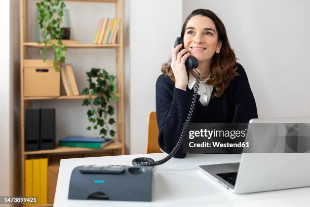 happy businesswoman talking on phone in office - telefone fixo imagens e fotografias de stock