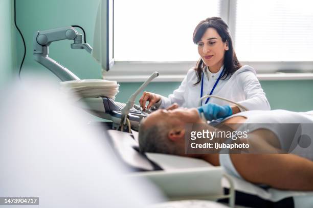femme médecin examinant le cou d’un patient à l’aide d’un appareil à ultrasons - human head photos et images de collection