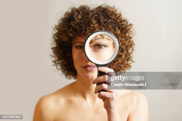 woman with magnifying glass against white background - looking through lens stock pictures, royalty-free photos & images