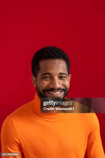 happy young man against red background - portrait fond rouge photos et images de collection