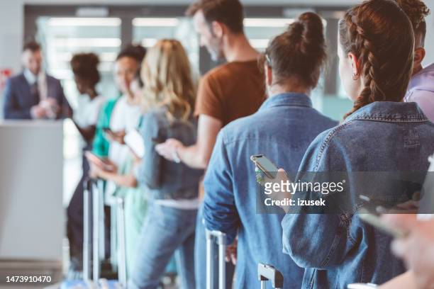 passengers with luggage waiting in line at airport - kö bildbanksfoton och bilder