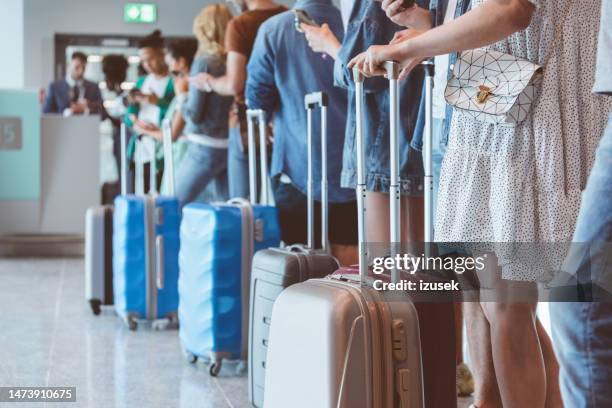 passagiere mit gepäck warten am flughafen in der schlange - flughafen check in stock-fotos und bilder