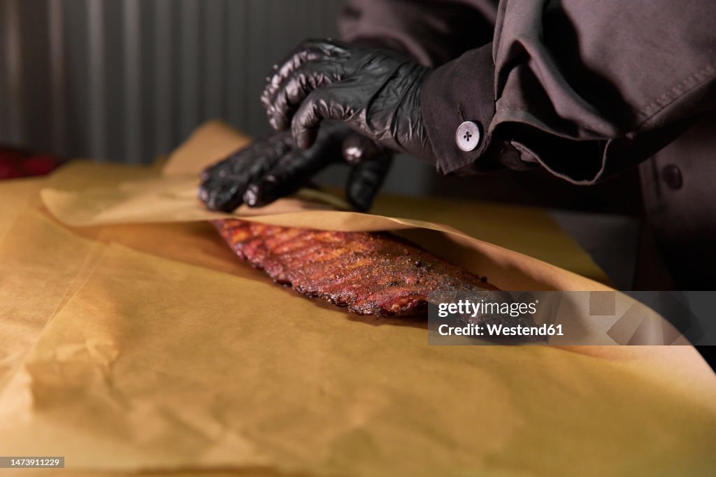 Chef wrapping meat in butcher paper