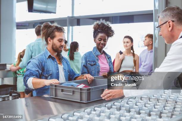 travelers standing at airport security check - security scanner stock pictures, royalty-free photos & images