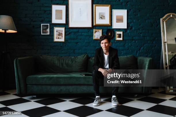 woman sitting on sofa at film set - executive producer stockfoto's en -beelden
