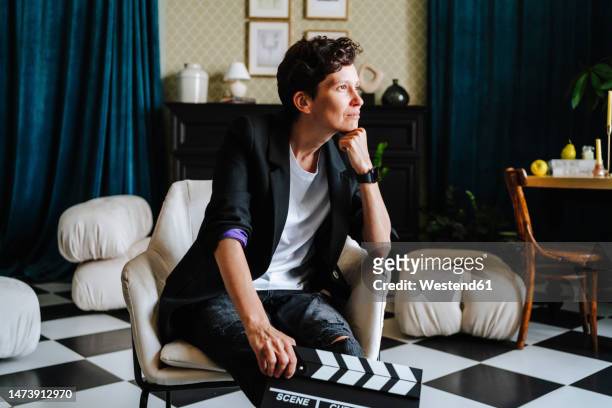 thoughtful director sitting on chair at film set - film director chair stock pictures, royalty-free photos & images