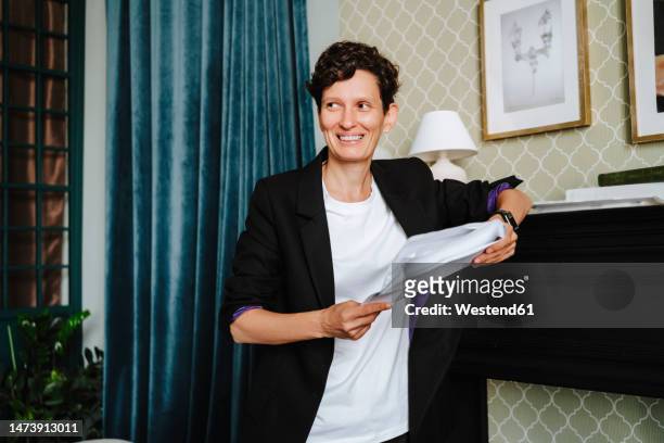 smiling director holding script at film set - androgyn stock pictures, royalty-free photos & images