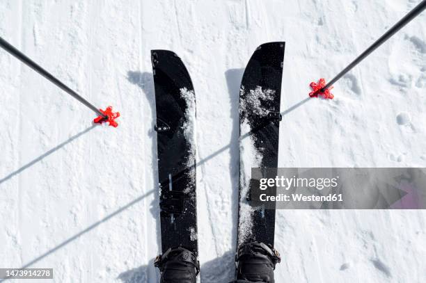 man wearing skis standing with poles in snow - ski pole stock pictures, royalty-free photos & images