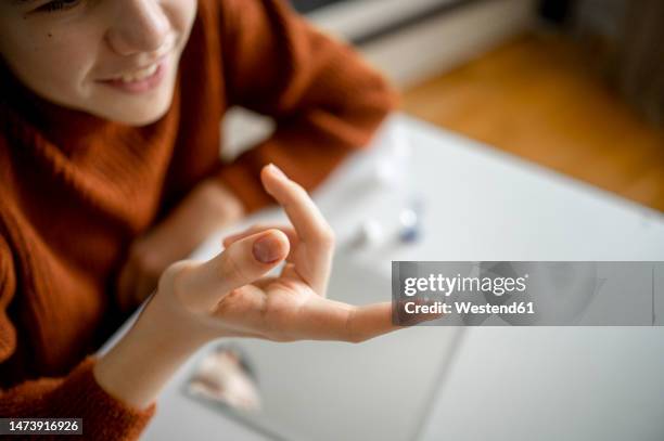 boy holding contact lens on finger at home - lente a contatto foto e immagini stock