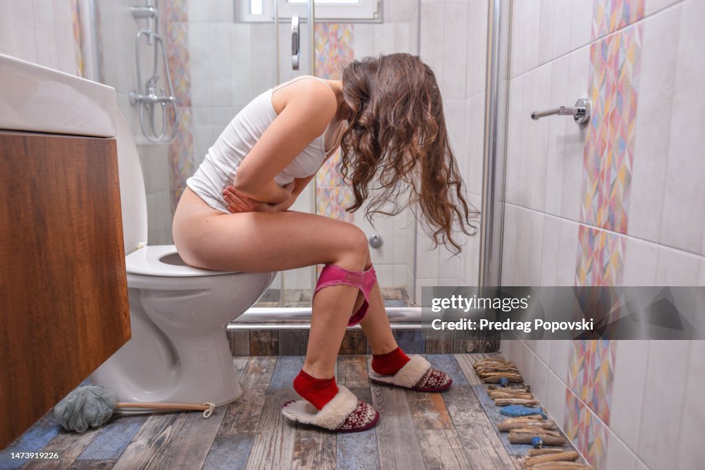 Woman with stomach pain on toilet