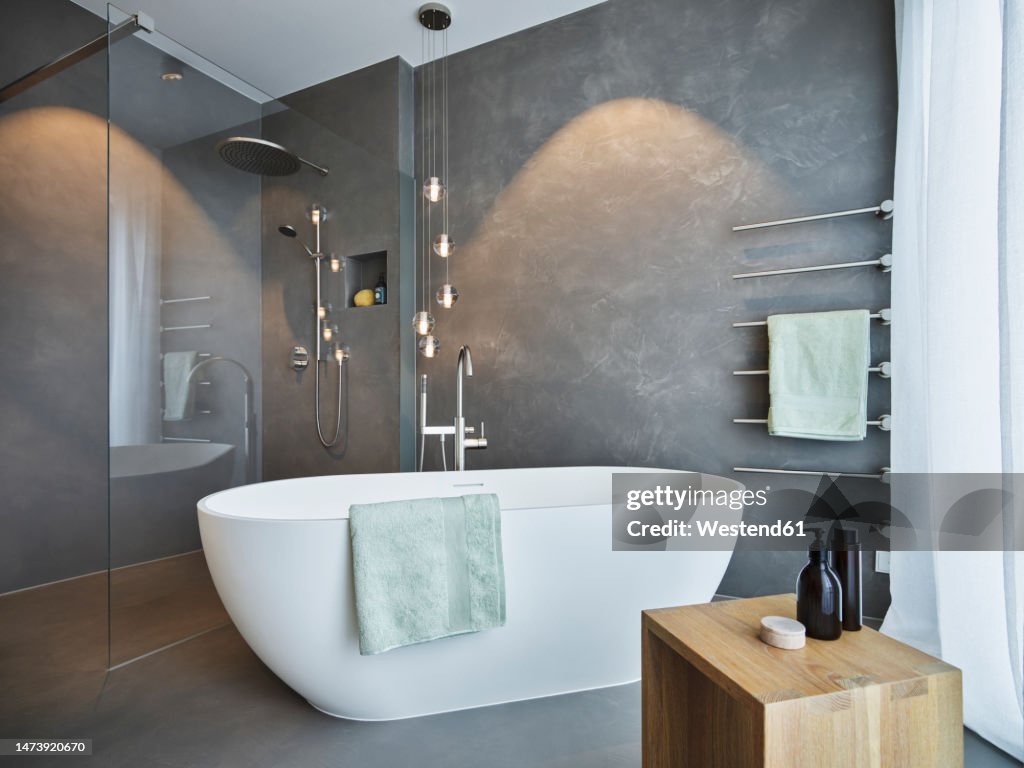 Empty bath tub arranged in bathroom of modern apartment
