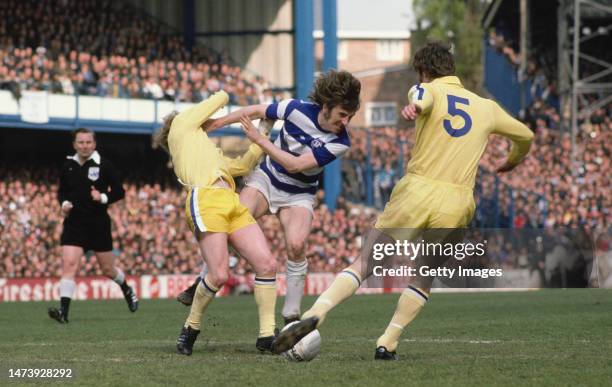 Striker Stan Bowles shrugs off the challenge of Leeds player Billy Bremner as Paul Madeley comes in during the First Division match berween Queens...