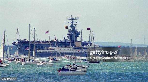 Her Majesty's yacht 'Britannia' passing US aircraft carrier during D-day 50th anniversary review, Gosport.