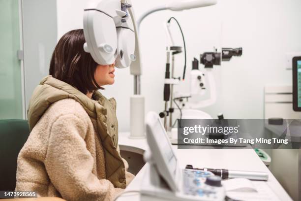 teenage girl having an eye exam at optometrist centre - exame oftalmológico imagens e fotografias de stock