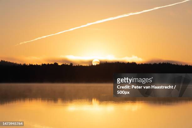 scenic view of lake against sky during sunset - sunset contrail stock pictures, royalty-free photos & images