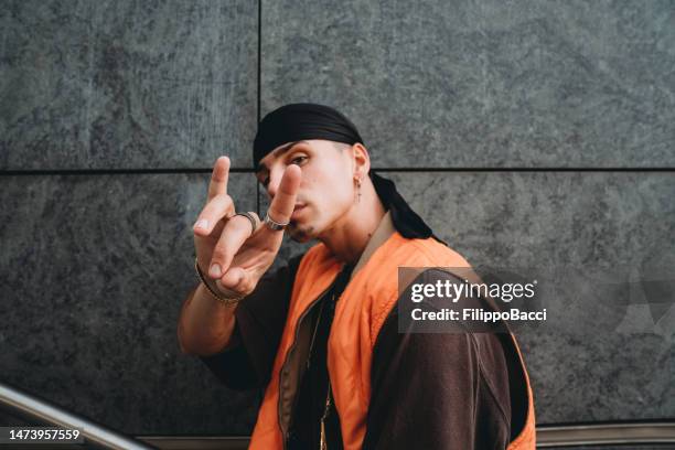 portrait of a young adult man wearing cool urban clothes in the city - hoorngebaar stockfoto's en -beelden